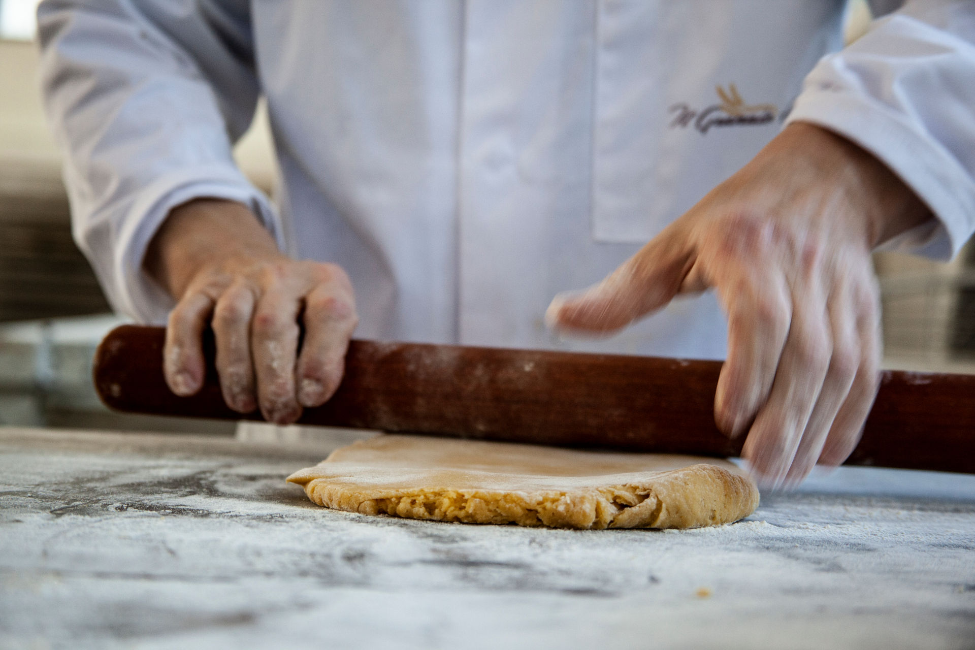 cuoco stende la massa del pane con farine speciali tipiche del forno Il Granaio Antico di Teramo