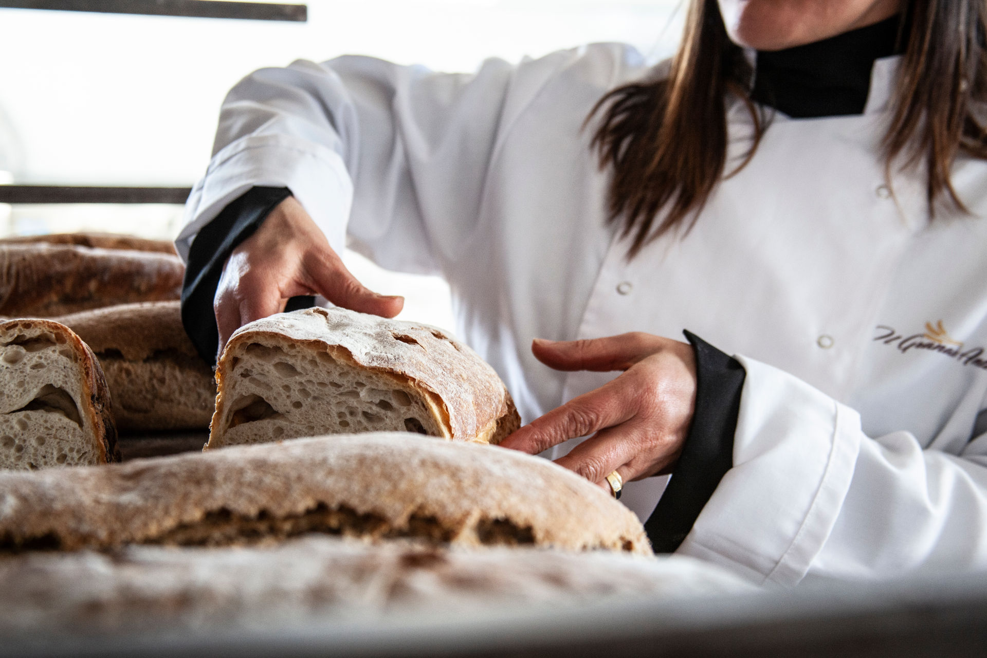 signoa prende con le mani il pane cafone con farine speciali tipiche del forno Il Granaio Antico di Teramo